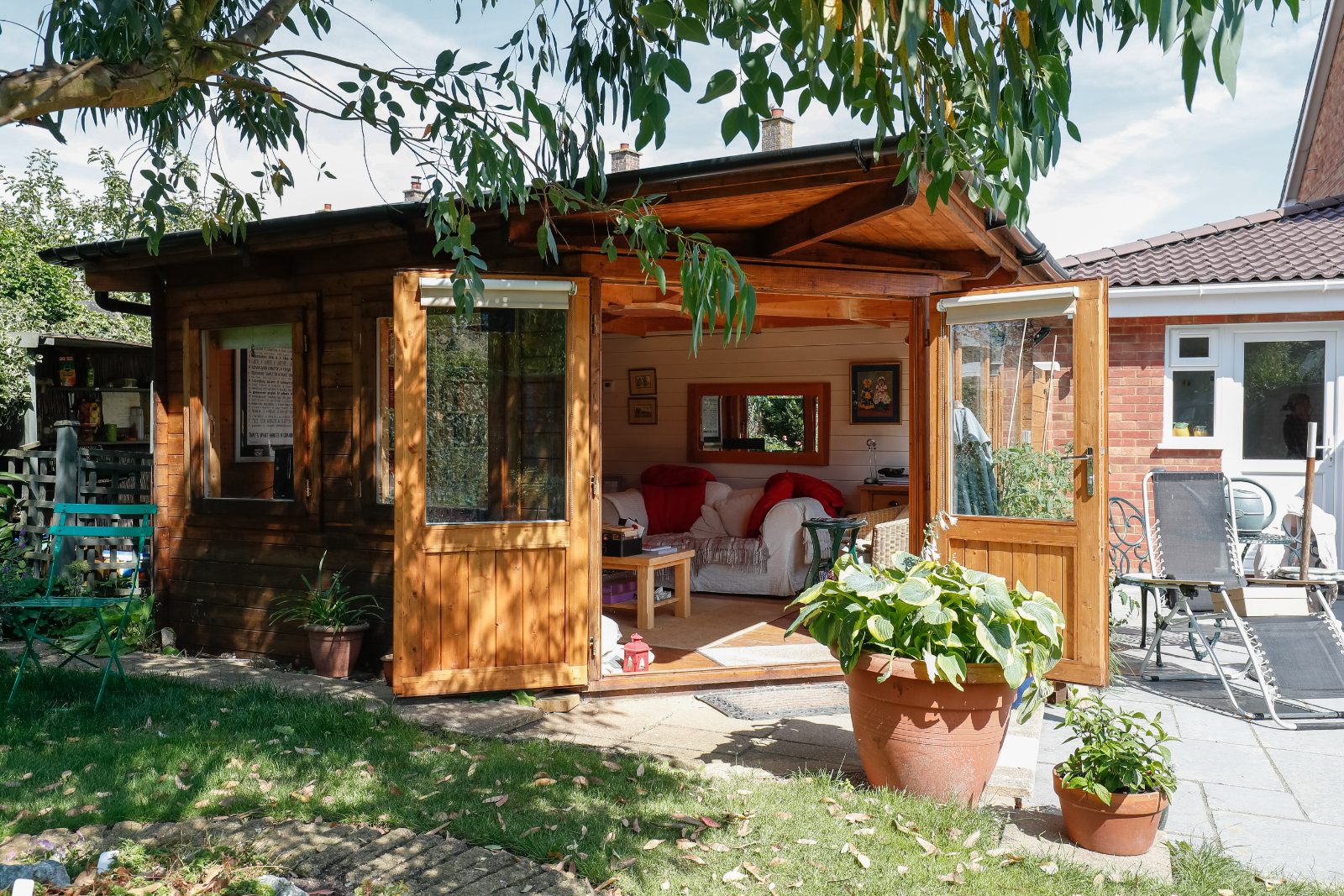 Garage converted into a bright home office with tall slim glazing replacing the original door